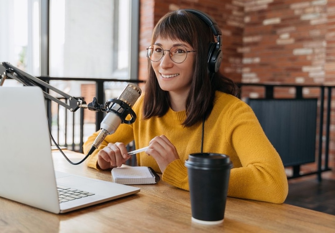 Female podcaster recording podcast at her desk